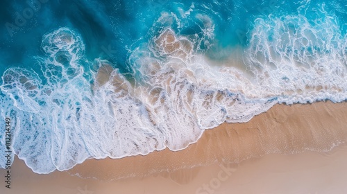 Sweeping aerial view of a beach with rolling blue waves  perfect for illustrating the tranquility and beauty of a summer vacation spot