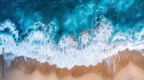 Vivid aerial shot of the dynamic interface between ocean waves and beach, illustrating the perfect summer holiday backdrop with natural blue tones