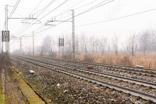 Deserted electric railway through the countryside on a foggy winter mornig