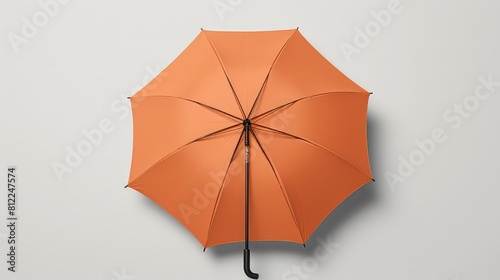 An orange umbrella with a black handle is open and laying on a white background © DX