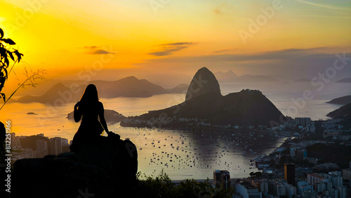 Rio de Janeiro, RJ, Brazil, 05/10/2024 - People watching the sunrise at Dona Marta viewpoint. The scenery shows Sugar Loaf Mountain and Botafogo Cove 