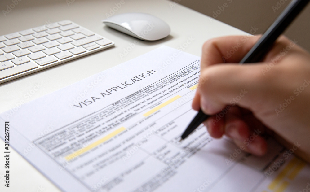 Close up of a female hand filling out a visa application document Close up of a female hand filling out a visa application document
