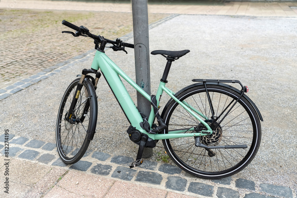 Bicycle strapped to a chair on a city street