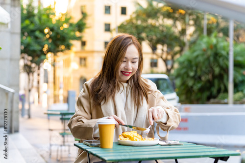 Photography Portrait of Happy Asian woman having lunch at outdoor restaurant during shopping in the city