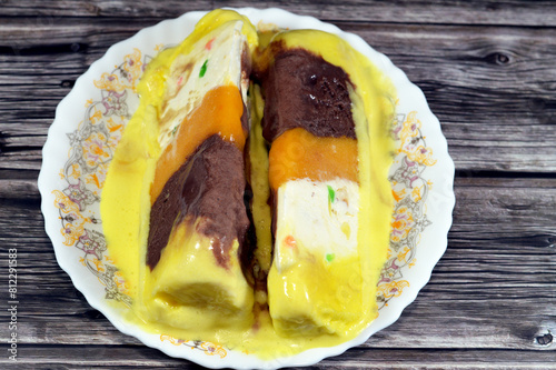 Gelato layer with New Zealand butter, whipped cream inside, and layers of cantaloupe, chocolate and mango, frozen dessert of ice cream with mixed flavors of chocolate, vanilla, mango and cantaloupe photo