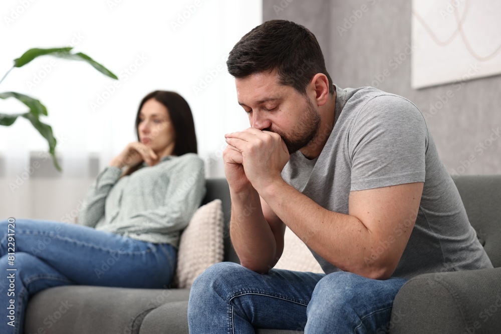 Offended couple ignoring each other after quarrel indoors, selective focus. Relationship problems Offended couple ignoring each other after quarrel indoors, selective focus. Relationship problems