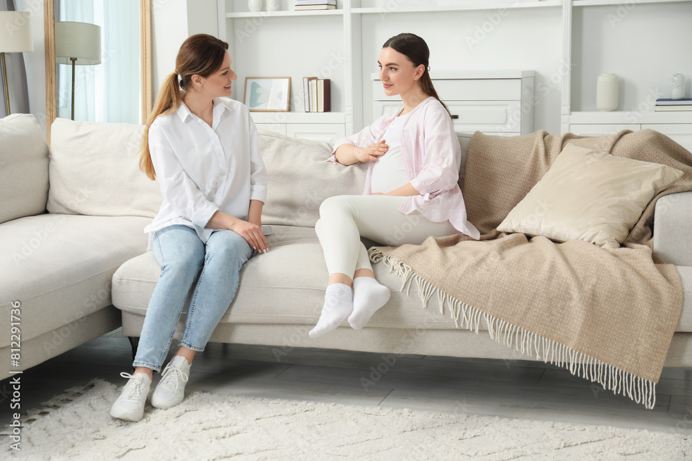 Doula working with pregnant woman on sofa at home. Preparation for child birth Doula working with pregnant woman on sofa at home. Preparation for child birth