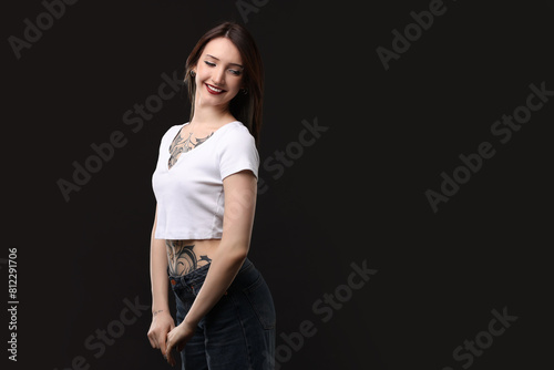 Portrait of smiling tattooed woman on black background. Space for text © New Africa