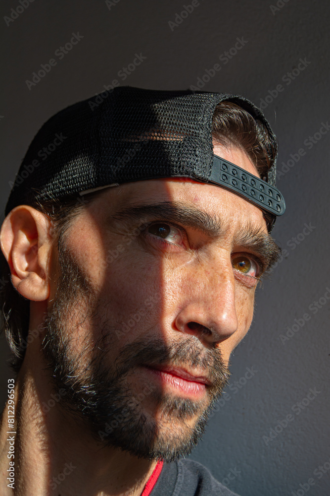Joven con gorra hacia atras con mirada pensatiba observadora Joven con gorra hacia atras con mirada pensatiba observadora