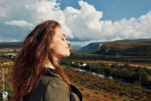Bilde på lerret A woman standing on a hill overlooking a valley, looking up at the sky in awe of