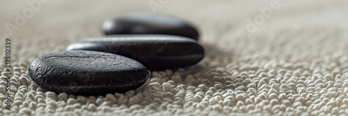 A soothing image of black zen stones in a row on a textured mat  symbolizing balance  harmony  and wellness