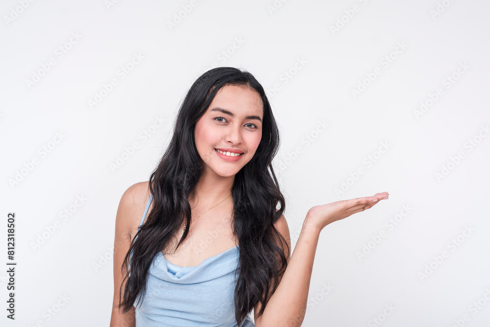 A cheerful young Asian woman wearing a baby blue dress, isolated on a white background, gestures invitingly towards the right. A cheerful young Asian woman wearing a baby blue dress, isolated on a white background, gestures invitingly towards the right.
