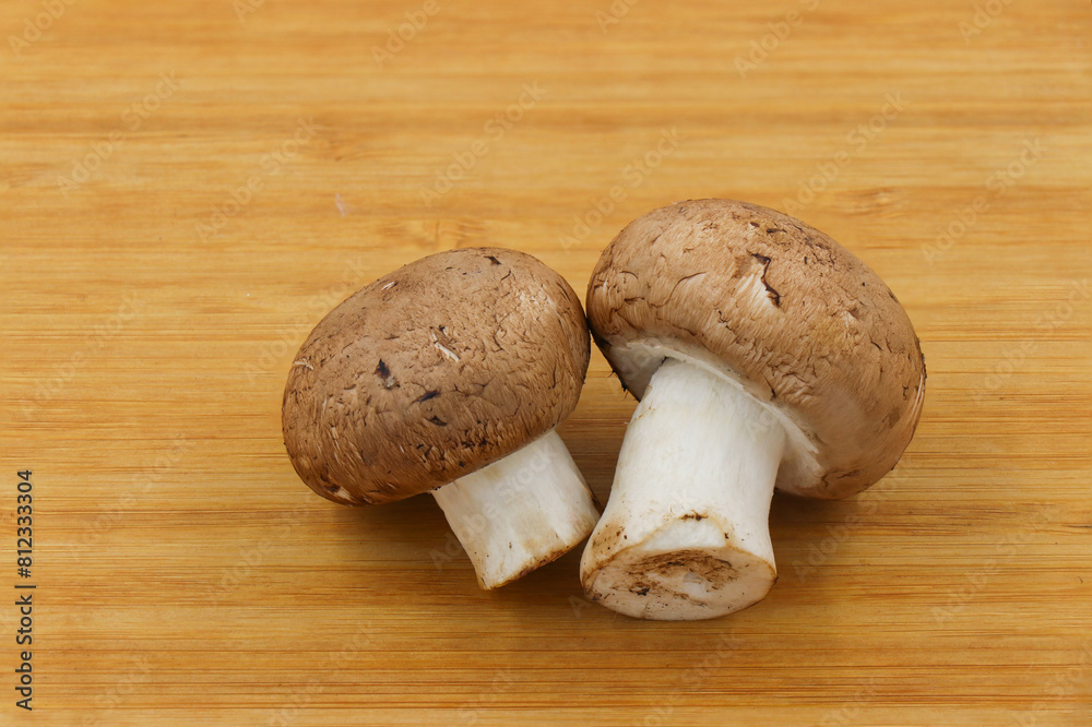 Fresh champignon mushroom isolated on wooden background Fresh champignon mushroom isolated on wooden background