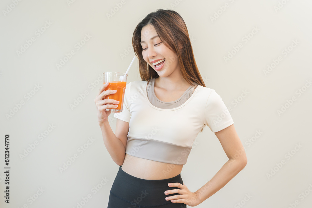 Orange detox juice, smile asian young woman hand holding a glass of vegetable juice, carrot smoothie for diet, drinking healthy meal food for weight loss on background. Lifestyle, vegan nutrition. Orange detox juice, smile asian young woman hand holding a glass of vegetable juice, carrot smoothie for diet, drinking healthy meal food for weight loss on background. Lifestyle, vegan nutrition.