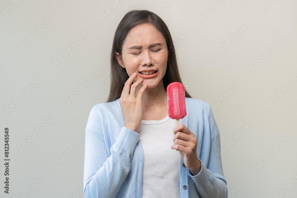 Face expression suffering from sensitive teeth and cold, asian young woman, girl hand touching cheek, hurt or pain eating ice cream. Toothache molar tooth, dental problem isolated on white background. Face expression suffering from sensitive teeth and cold, asian young woman, girl hand touching cheek, hurt or pain eating ice cream. Toothache molar tooth, dental problem isolated on white background.