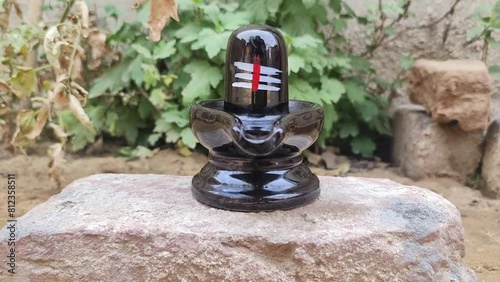 Lord Shiva religious symbol black marble shivlinga sculpture selective focus on natural background  photo