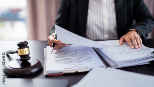 Lawyer businesswoman holding document to reading lawsuit and checking about financial business data while analysis about legislation agreement and terms data of business contract in law firm photo