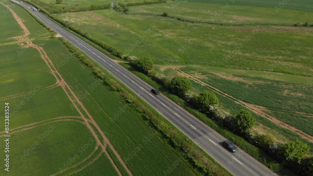 Flying over traffic on a busy main road going between fields of wheat Flying over traffic on a busy main road going between fields of wheat