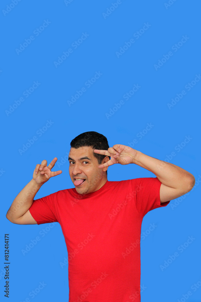 Naklejka premium Dark-skinned Latino adult man makes the victory sign with his fingers happy and excited