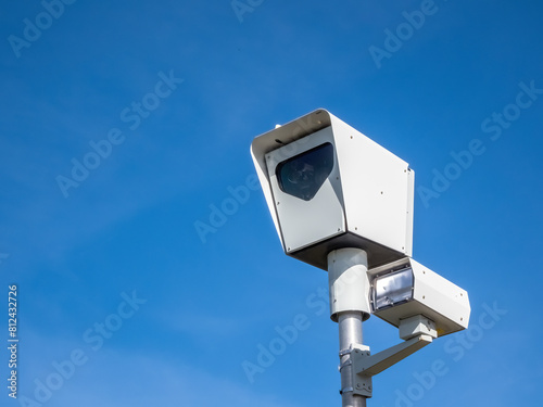 A close up to a traffic speed Camera or red light camera on a sunny day with a blue sky.