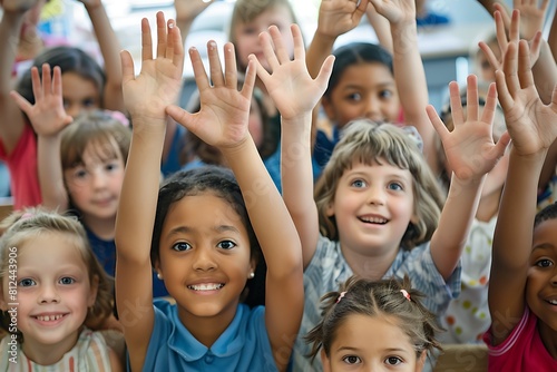 group of school kids raising hands in classroom