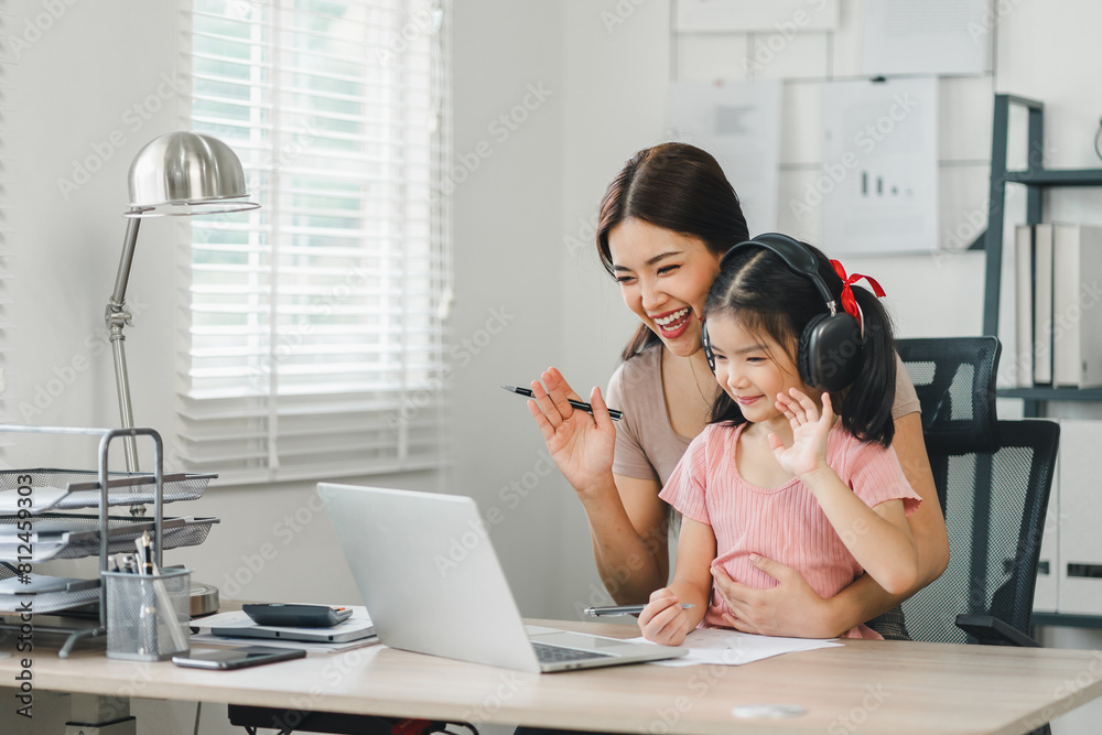 Smiling mother and daughter enjoying online communication together at home office. Smiling mother and daughter enjoying online communication together at home office.