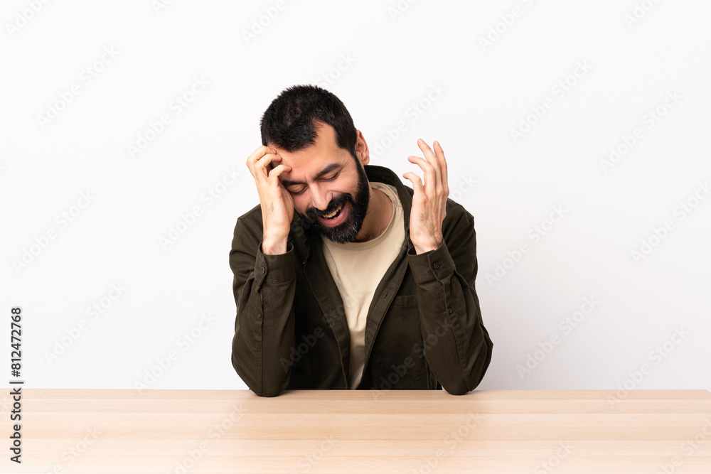 Caucasian man with beard in a table laughing. Caucasian man with beard in a table laughing.