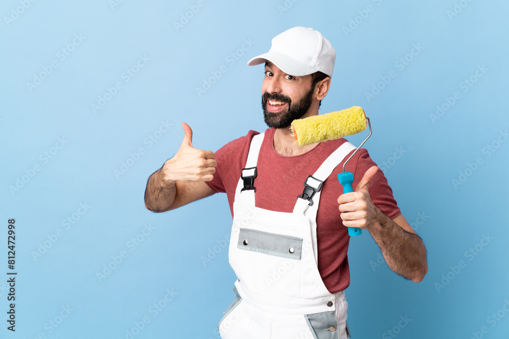 Adult painter man over isolated blue background giving a thumbs up gesture Adult painter man over isolated blue background giving a thumbs up gesture