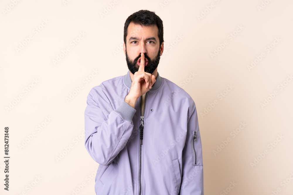 Caucasian man with beard wearing a jacket over isolated background showing a sign of silence gesture putting finger in mouth Caucasian man with beard wearing a jacket over isolated background showing a sign of silence gesture putting finger in mouth