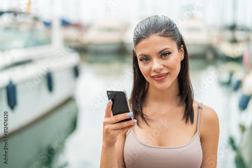 Young pretty woman at outdoors using mobile phone