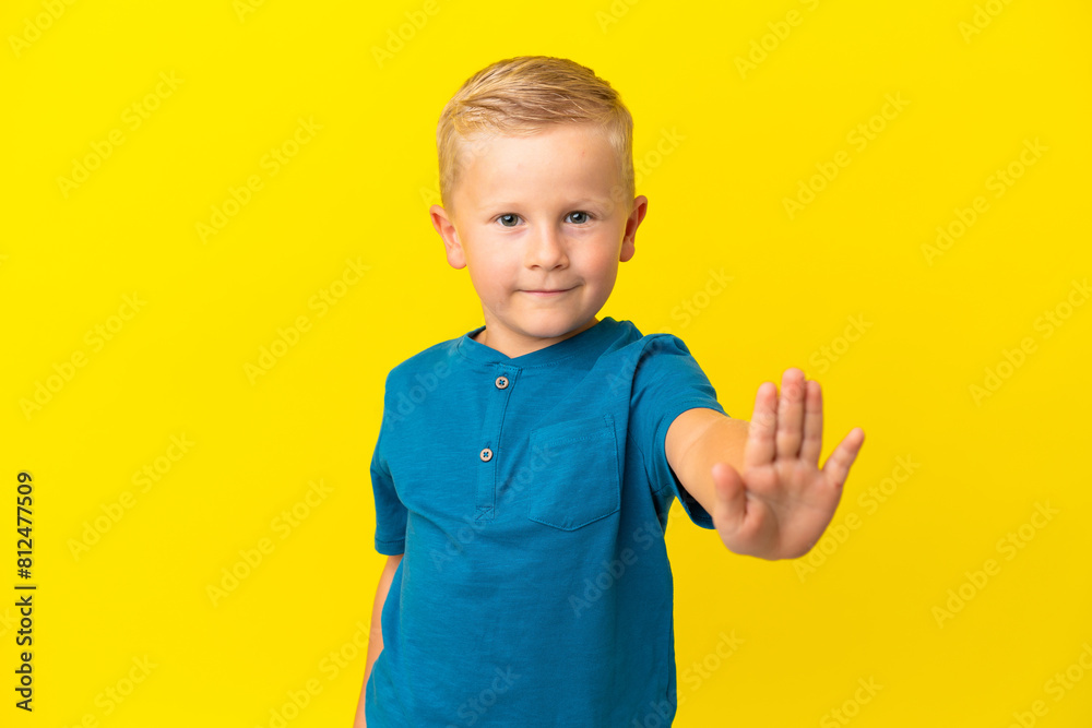 Little Russian boy isolated on yellow background making stop gesture Little Russian boy isolated on yellow background making stop gesture