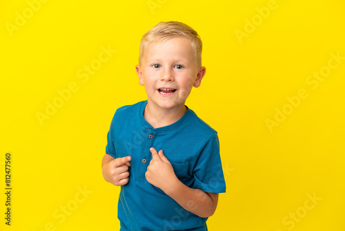 Little Russian boy isolated on yellow background with surprise facial expression photo