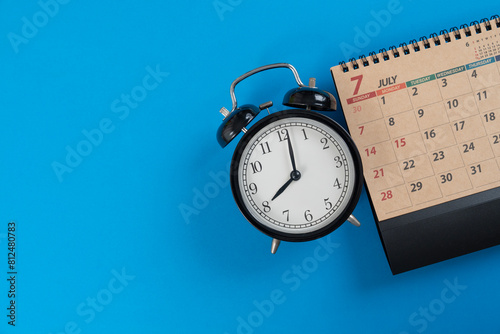 close up of calendar and alarm clock on the blue table background, planning for business meeting or travel planning concept