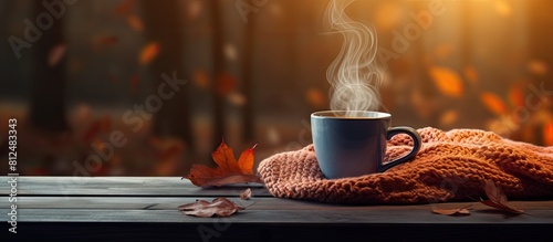 An inviting scene with a hot cup of cozy drink and an autumn sweater placed on a table providing ample space for text in the image photo