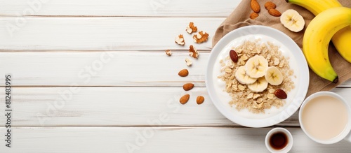 Healthy and vegetarian breakfast with a white plate containing oatmeal porridge nuts and a banana The image has copy space