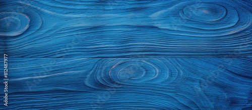 A close up view of a blue wooden surface with a textured pattern captured in a top view perspective and providing ample space for imagery