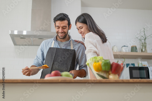 Happy young couple cooking together in the kitchen at home
