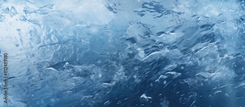 Close up of a frozen river with cracked ice covered in white snow and revealing the deep blue water underneath This copy space image showcases the texture of the ice