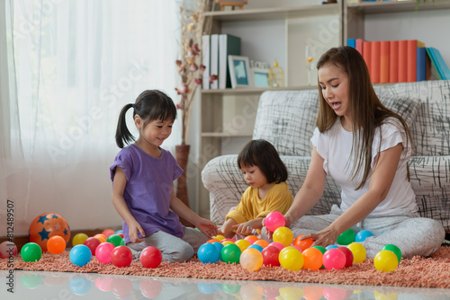 Asian family mother and child daughter are playing colorful balls
