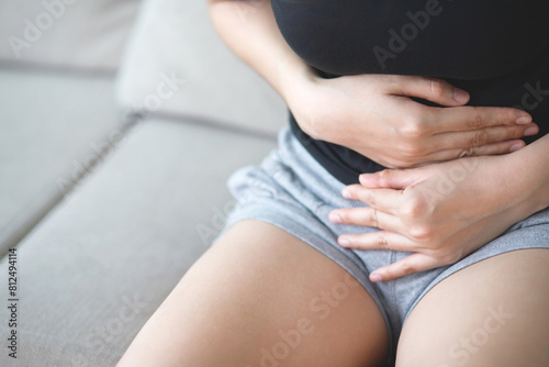Woman having a stomachache, or menstruation pain. suffering from abdominal. Menstrual cramps. Healthcare and medical, gynecology concept. © methaphum