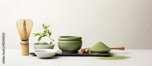 A copy space image featuring matcha powder and tea ceremony tools arranged on a white background