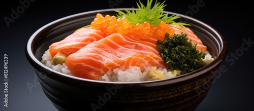 A copy space image featuring a salmon donburi with sliced raw salmon placed on top of cooked rice and accompanied by salmon roe