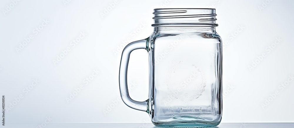 © HN Works - A vintage mason jar is displayed on a white background featuring a lid and handle The image includes a reflection and has ample copy space