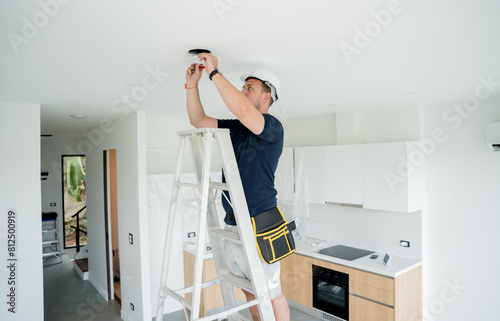 Bild auf Leinwand technician is installing an LED spotlight in the ceiling.