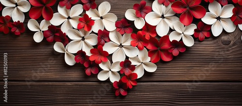 The paper flowers crafted in a heart shape representing Valentine s Day showcase a vibrant combination of red and white petals A top view angle reveals the flowers exquisite design displayed on a woo photo