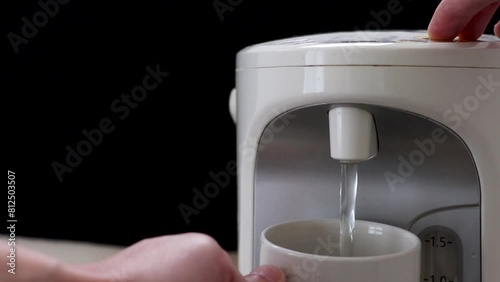電気ポットからマグカップにお湯を注ぐ