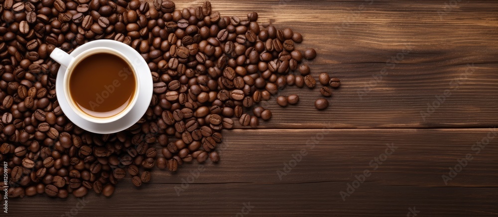 A top view of hot coffee and coffee beans arranged on a wooden background is displayed in the copy space image A top view of hot coffee and coffee beans arranged on a wooden background is displayed in the copy space image