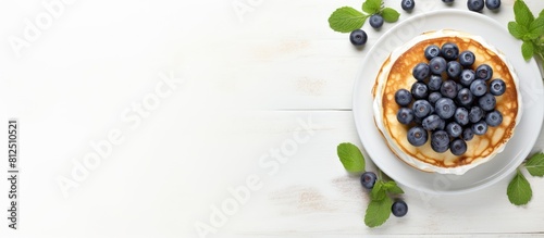 Top view of a copy space image featuring light background with cottage cheese pancakes sour cream and blueberries Suitable for breakfast or lunch photo