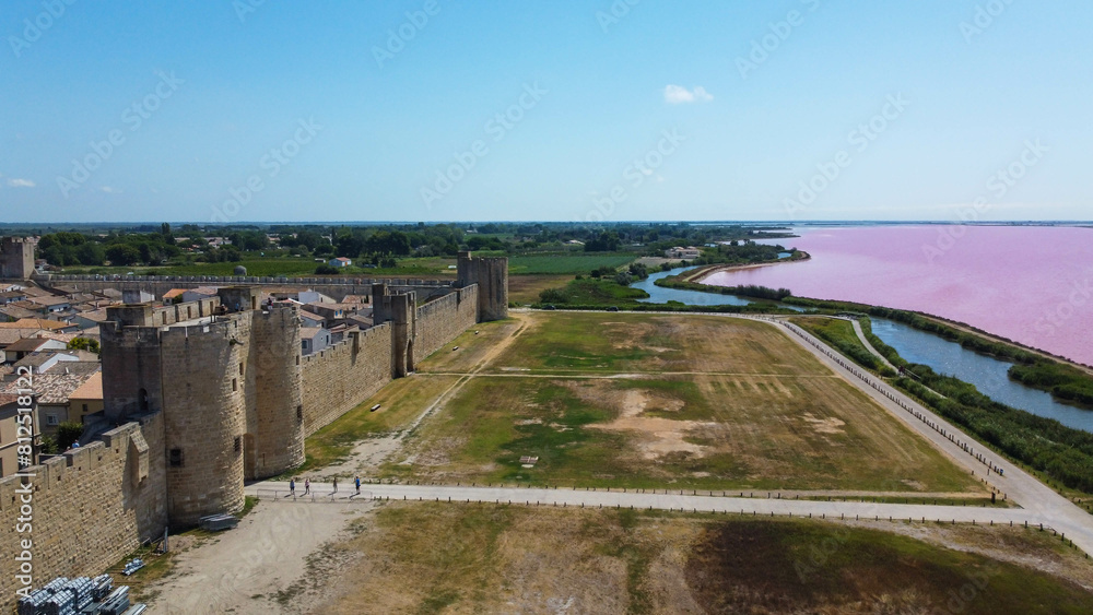 Fortified city of Aigues-Mortes, in Provence in France. Entirely surrounded by an imposing city wall and purple salt pans of incredible beauty, Aigues-Mortes is a jewel, an enchanting medieval village Fortified city of Aigues-Mortes, in Provence in France. Entirely surrounded by an imposing city wall and purple salt pans of incredible beauty, Aigues-Mortes is a jewel, an enchanting medieval village