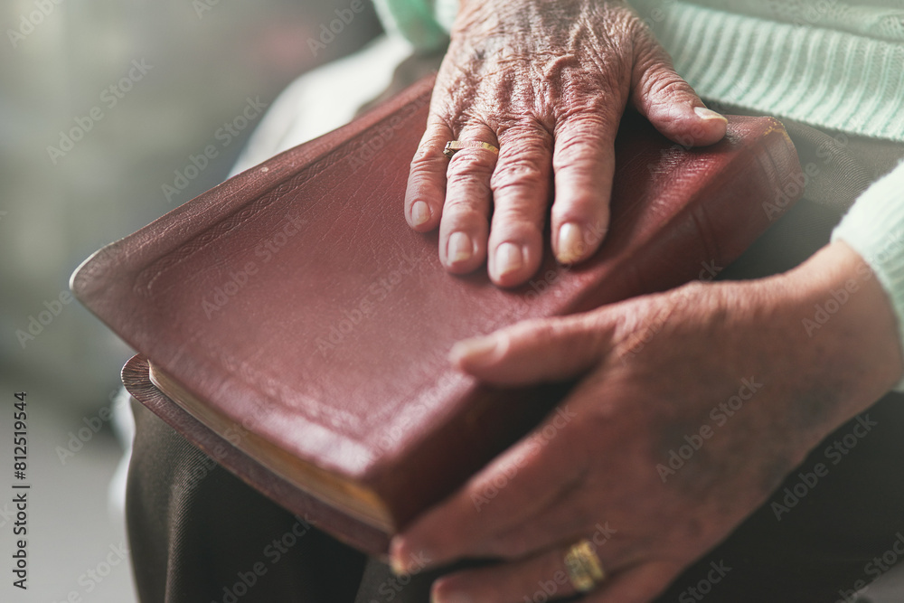Fototapeta premium Senior woman, hand and bible with prayer for worship, faith and spiritual healing at home. God, support and elderly person with religious book in house for scripture, testament and Christian wisdom